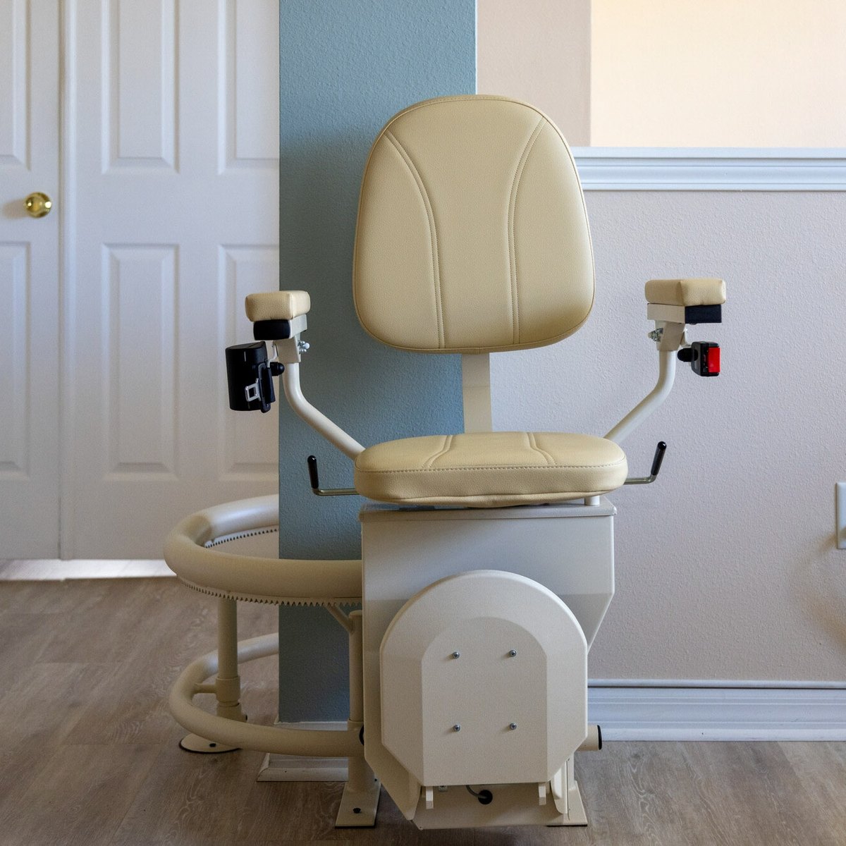 Beige Helix curved stair lift parked at the bottom of the rail