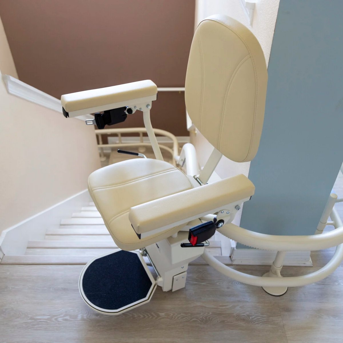 Harmar Helix curved stair lift at the foot of a turning staircase