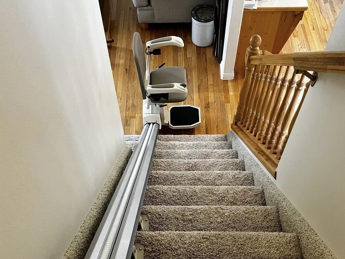 Lazo install: lift parked at the far end of the rail past carpeted steps
