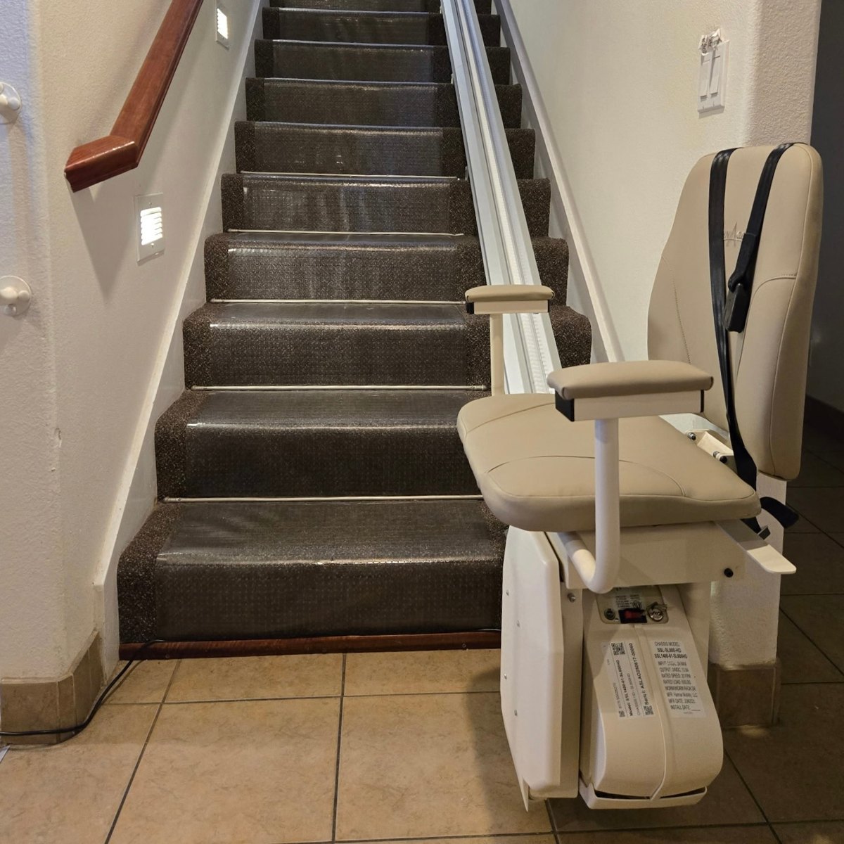 Harmar SL600HD stair lift installed at the foot of a carpeted staircase